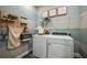 Well-organized laundry room with modern washer, dryer and decorative accessories at 10267 Fieldstone Myrtle Way, San Antonio, FL 33576