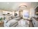 Open concept living room with large sofa, statement lighting, and an adjacent modern kitchen at 10267 Fieldstone Myrtle Way, San Antonio, FL 33576