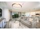 Spacious living area featuring a plush sofa, contemporary lighting, and seamless flow to the outdoor patio at 10267 Fieldstone Myrtle Way, San Antonio, FL 33576