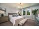 Comfortable main bedroom with white brick accent wall, chandelier and a view of the green yard at 10267 Fieldstone Myrtle Way, San Antonio, FL 33576