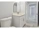 Contemporary bathroom with a sleek vanity, arched mirror, and modern fixtures, complemented by stylish gray flooring at 104 1St Ne Ave, Lutz, FL 33549