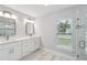 Bright bathroom with double vanity, tile flooring, and a glass enclosed shower at 104 1St Ne Ave, Lutz, FL 33549