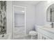Updated bathroom with tiled shower and modern vanity, adjacent to a well-lit room with stylish flooring at 104 1St Ne Ave, Lutz, FL 33549