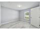 Well-lit bedroom with a large window, neutral paint, and modern flooring for a clean and inviting space at 104 1St Ne Ave, Lutz, FL 33549