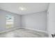 Bright bedroom with natural light, featuring wood-look flooring, neutral walls, and a view of the outdoors at 104 1St Ne Ave, Lutz, FL 33549