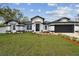 Striking single-story home featuring a black and white exterior, two car garage and well-manicured lawn at 104 1St Ne Ave, Lutz, FL 33549