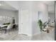 Bright hallway featuring light gray walls, stylish gray flooring, and an open dining space at 104 1St Ne Ave, Lutz, FL 33549