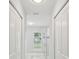 Hallway features closets with tile flooring, connecting various rooms in the home at 104 1St Ne Ave, Lutz, FL 33549