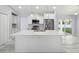 Bright kitchen features stainless steel appliances, white cabinetry, a decorative light fixture and quartz countertops at 104 1St Ne Ave, Lutz, FL 33549