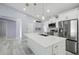 Spacious kitchen showcasing a center island with seating, stainless steel appliances, and plenty of storage at 104 1St Ne Ave, Lutz, FL 33549