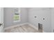 Bright laundry room featuring grey paint, tile floors, window, and washer/dryer hookups at 104 1St Ne Ave, Lutz, FL 33549