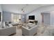 Comfortable living room featuring modern gray furniture, a ceiling fan, and stylish flooring at 104 1St Ne Ave, Lutz, FL 33549