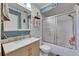 Charming bathroom with modern sink vanity, ample storage, and a bathtub/shower combo with sliding glass doors at 10719 Drummond Rd, Tampa, FL 33615
