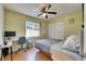 Bright bedroom featuring a ceiling fan, large window with natural light, and a dedicated desk area at 10719 Drummond Rd, Tampa, FL 33615