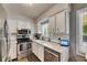 The kitchen offers stainless steel appliances, a window with natural light, and white cabinets at 10719 Drummond Rd, Tampa, FL 33615