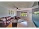 Bright living room featuring hardwood floors, modern ceiling fan, and a large window for natural light at 10719 Drummond Rd, Tampa, FL 33615