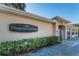 Exterior view of Virginia Crossing building with well-maintained landscaping and signage at 1145 Dixon Ct, Dunedin, FL 34698