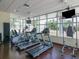 Bright gym with treadmills, elliptical machines, TV screens, and floor-to-ceiling windows at 1208 E Kennedy Blvd # 1122, Tampa, FL 33602