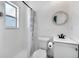 Bathroom featuring a shower with updated fixtures, white tile surround, and a framed vanity mirror at 12310 Mallory Dr, Largo, FL 33774