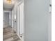 Hallway with several doors leading to rooms with light wood-look flooring and modern lighting at 12310 Mallory Dr, Largo, FL 33774