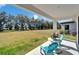 Covered back porch with table and chairs overlooking a large grassy yard at 14733 Gallop Run Dr, Lithia, FL 33547
