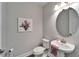 Charming powder room featuring a pedestal sink, oval mirror, and tasteful floral decor at 14733 Gallop Run Dr, Lithia, FL 33547