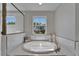 Bathroom featuring a soaking tub and window with a view at 14733 Gallop Run Dr, Lithia, FL 33547