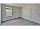 Inviting bedroom features neutral carpet, a window, and a classic white door with hardware at 14733 Gallop Run Dr, Lithia, FL 33547