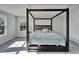Bright bedroom featuring neutral walls, a four-poster bed, and three large windows at 14733 Gallop Run Dr, Lithia, FL 33547