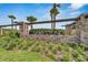 Stone entrance to Hawkstone community with professionally manicured landscaping, stone wall, and green bushes at 14733 Gallop Run Dr, Lithia, FL 33547