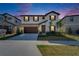 Charming two-story home with a stone facade, a well-manicured lawn, and a two car garage at twilight at 14733 Gallop Run Dr, Lithia, FL 33547