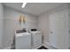 Efficient laundry room featuring front load washer and dryer with upper shelving for supplies at 14733 Gallop Run Dr, Lithia, FL 33547