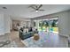 Bright living room features modern furniture, and sliding doors to a patio and backyard at 14733 Gallop Run Dr, Lithia, FL 33547