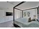 Bedroom featuring a four-poster bed, tv, and double windows for ample natural light at 14733 Gallop Run Dr, Lithia, FL 33547