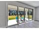 Covered patio with sliding glass doors, table and chairs with a view of the lawn at 14733 Gallop Run Dr, Lithia, FL 33547
