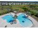 Community dual swimming pool area, showcasing lounge seating and landscaping, with nearby homes and wetlands at 14733 Gallop Run Dr, Lithia, FL 33547