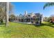 Spacious backyard with in-ground pool, screened enclosure, green lawn and established trees for privacy at 15703 Jericho Dr, Odessa, FL 33556