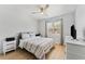 Bright bedroom featuring a ceiling fan, a large window, and a plush bed with striped linens at 15703 Jericho Dr, Odessa, FL 33556