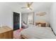 Charming bedroom featuring a decorative ceiling fan, a plush bed with pillows, and natural light from the window at 15703 Jericho Dr, Odessa, FL 33556