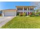 Traditional two-story home with white columns, shutters, attached garage and well manicured lawn at 15703 Jericho Dr, Odessa, FL 33556