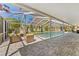 Enclosed pool area with a screened-in pool, outdoor seating, and well-maintained patio at 15703 Jericho Dr, Odessa, FL 33556