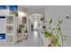 Hallway with decor, plants and tile flooring leads to the front door with natural light at 16724 Mooner Plank Cir, Wimauma, FL 33598