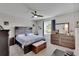 Serene main bedroom with a wooden headboard, ceiling fan, and ample natural light at 16724 Mooner Plank Cir, Wimauma, FL 33598