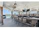 Enjoy drinks at the outdoor bar overlooking the community lagoon with seating, televisions, and tropical ceiling fans at 16946 Oval Rum Dr., Wimauma, FL 33598