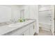 Bright bathroom featuring double sinks with granite countertops and a shower with glass doors at 16946 Oval Rum Dr., Wimauma, FL 33598