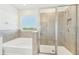 Modern bathroom with a glass-enclosed shower, a soaking tub, and a large window at 16946 Oval Rum Dr., Wimauma, FL 33598