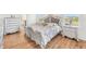 Luxurious bedroom with a large bed, wood floors, and ample natural light through window at 16946 Oval Rum Dr., Wimauma, FL 33598