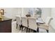 Bright dining room featuring a table with seating for six, large windows, and elegant decor at 16946 Oval Rum Dr., Wimauma, FL 33598