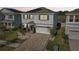 Charming two-story home featuring a paver driveway, manicured landscaping, and a welcoming entryway at 16946 Oval Rum Dr., Wimauma, FL 33598
