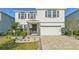 Charming two-story home featuring a two-car garage, stone accents, a well-manicured lawn, and beautiful landscaping at 16946 Oval Rum Dr., Wimauma, FL 33598